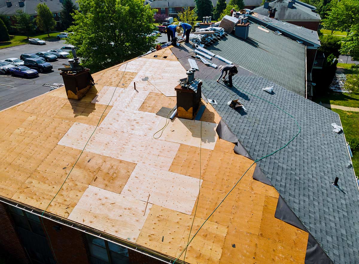 roofer with an insurance policy replacing roof shingles