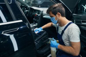 Male wiping a car while working for a cleaning business