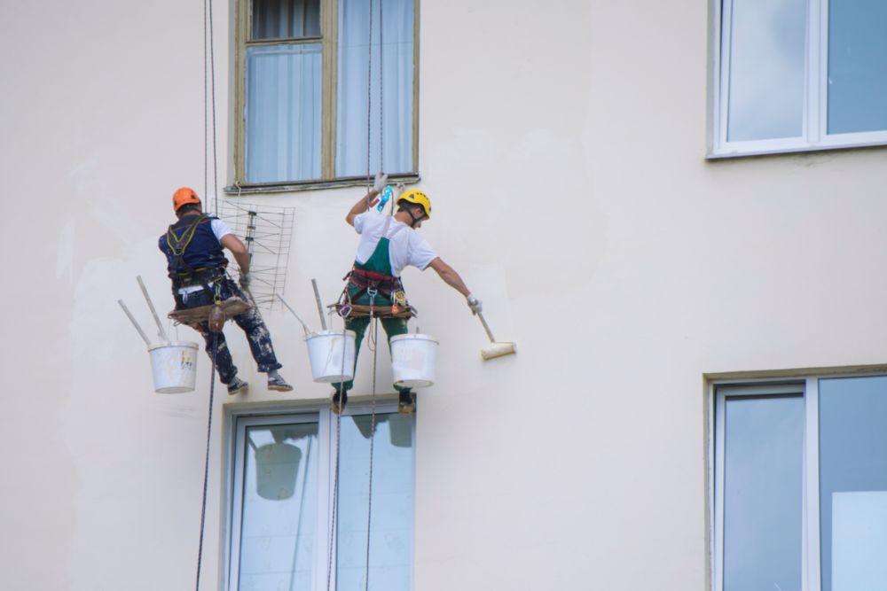 Two painters painting in a high risk environment