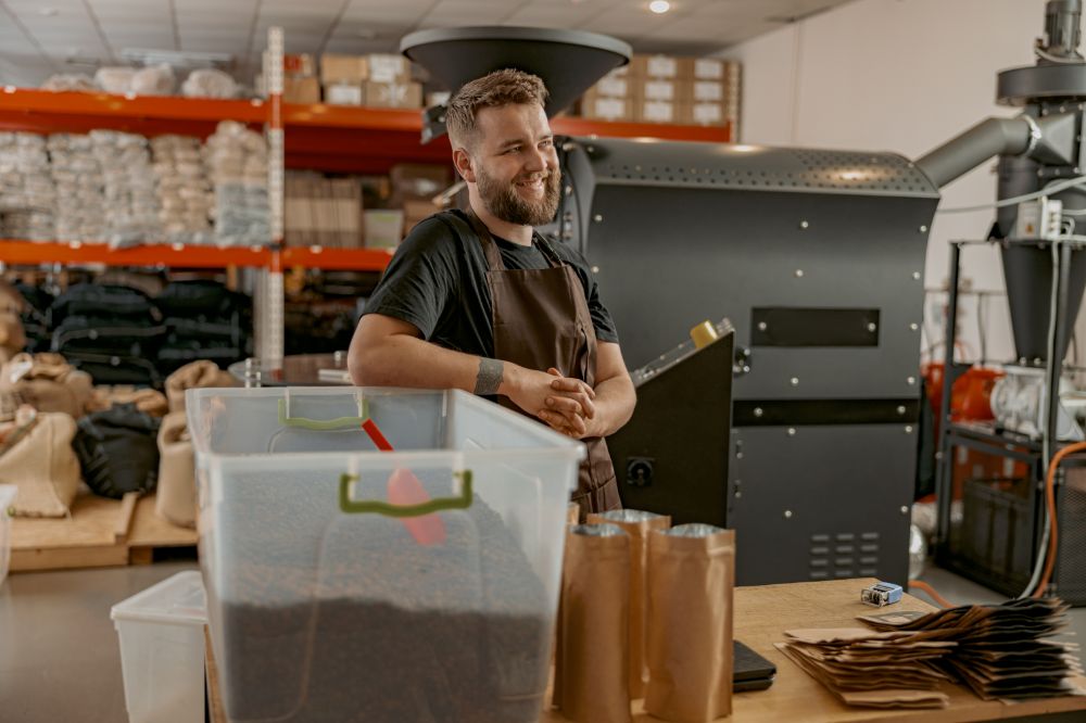 Business owner in his store smiling, knowing he's covered by sole trader insurance