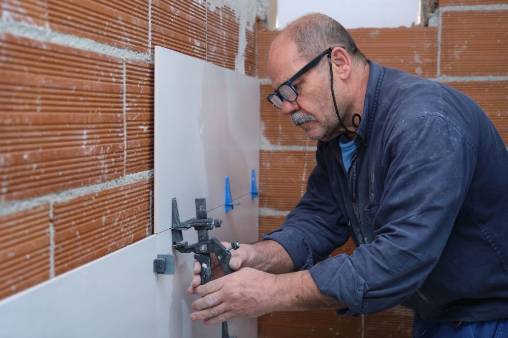 Australian man adding tiles to a clients wall