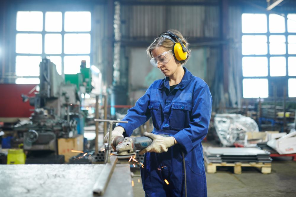 Tradie in workshop cutting metal with safety gear on