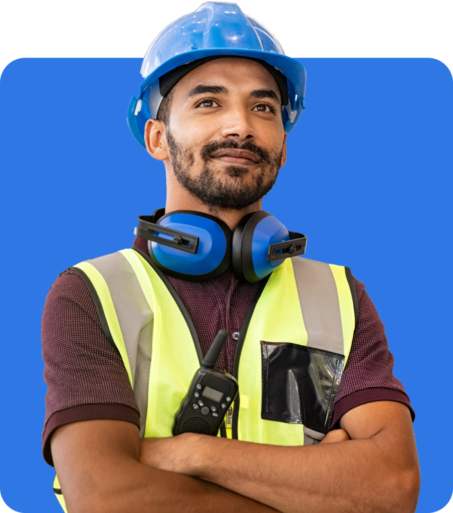 A construction worker wearing a blue hard hat, safety vest, and earmuffs stands with arms crossed against a solid blue background, symbolizing the strength and security offered by Bricklayers Insurance.