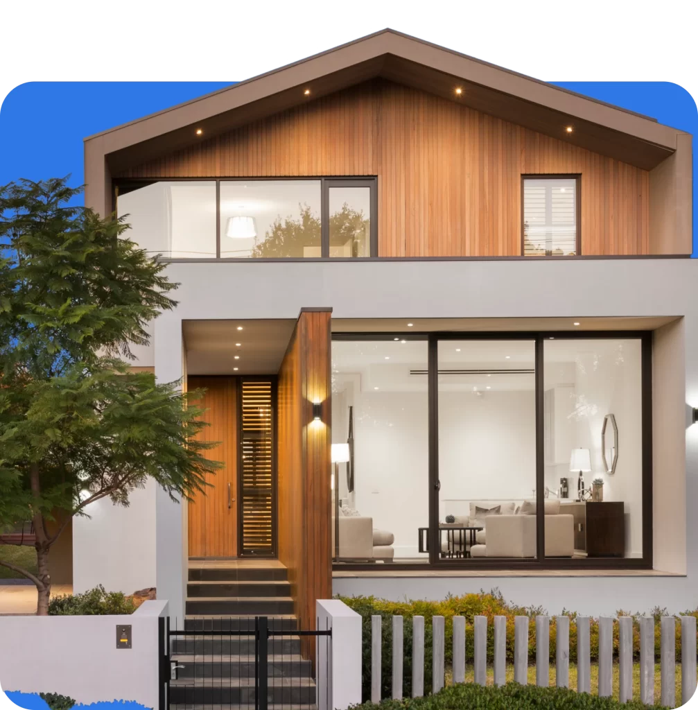 A modern two-story house with large glass windows, wooden paneling, and white exterior walls stands proud. The property, ideal for Prestige Home Insurance, features a small front yard with minimal landscaping and a black metal fence.