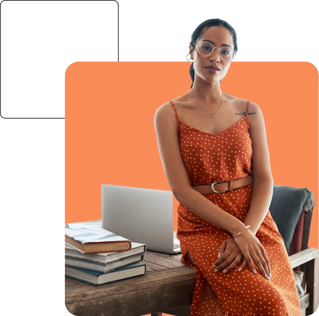 A person in a sleeveless polka dot dress and glasses sits on a table with a laptop and stack of books nearby, all set against an orange background. The scene exudes the calm confidence one might feel when secure with Prestige Home Insurance.