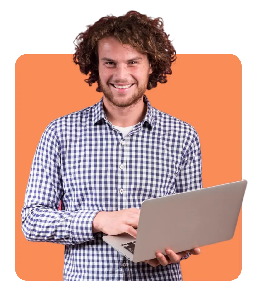 A person with curly hair and a checkered shirt is smiling while holding an open laptop with both hands. The background is a solid orange color.