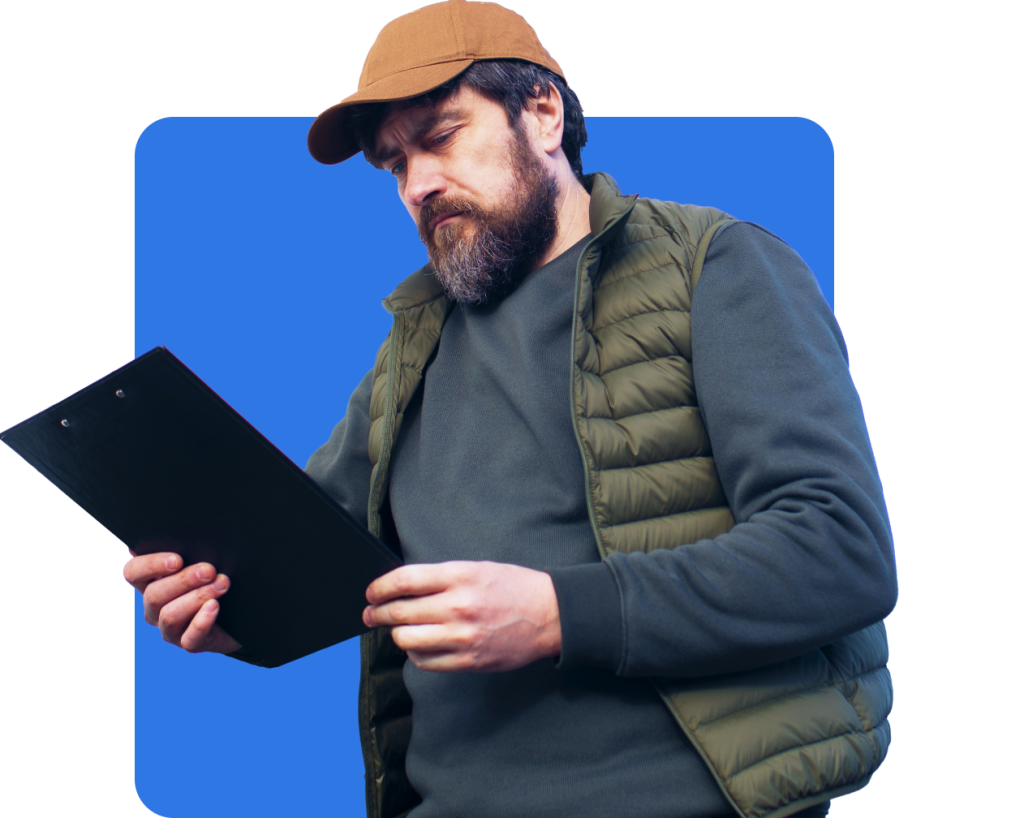 A truck driver carefully reads a schedule on a clipboard.